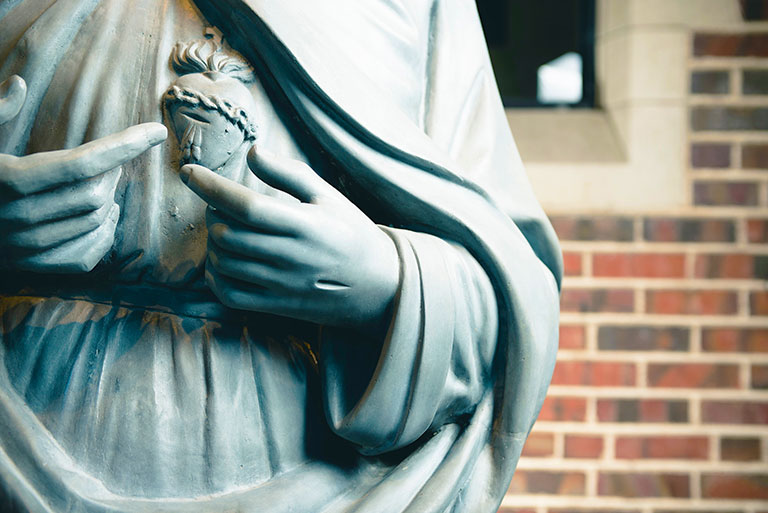 closeup of a statue of Jesus with flaming heart on the Northwest Denver campus