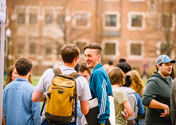 students stand in small groups on the Quad during ranger week activities