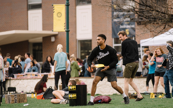 Regis University students playing yard games and gathering on campus during a student event