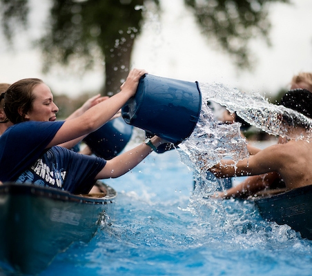 Regis University students participating in a canoe activity on the water.