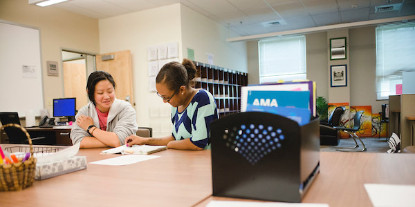 a staff member tutors a student in the Learning Commons on the Northwest Denver Campus