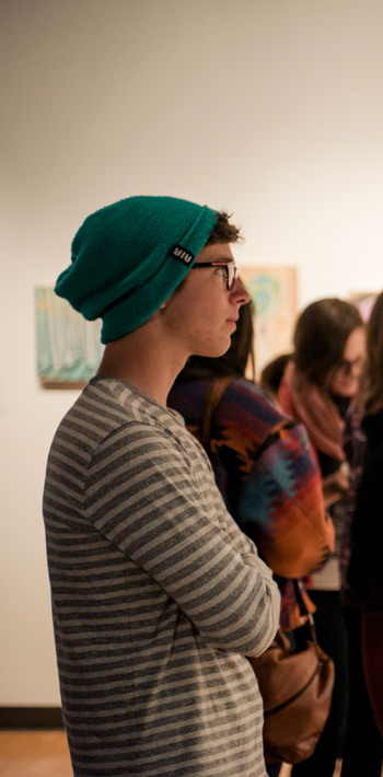 Regis University students viewing artwork in a campus gallery.