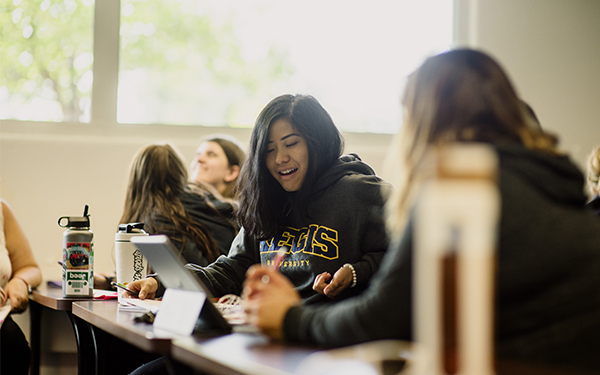 student laughing in class at desks