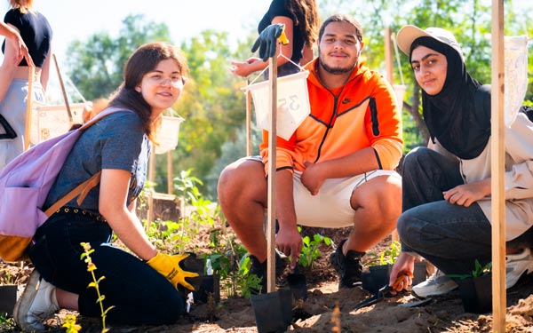 Students working together to plant seedlings as part of a community or sustainability project.