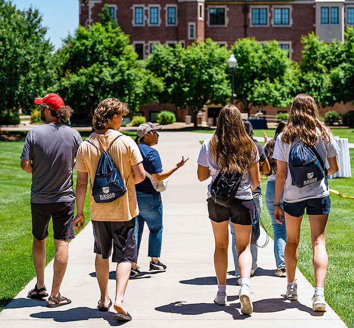 a group of prospective students is lead across the Quad by their tour guide during Super Saturday on the Northwest Denver campus