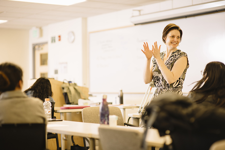 teacher clapping looking at students