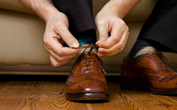 person tying a dress shoe