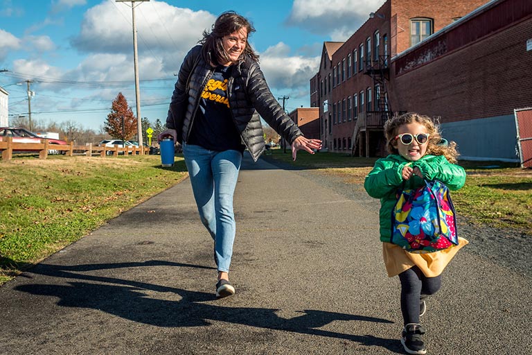 Woman runs to catch up with young child on outdoor trail