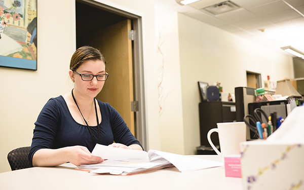 woman at desk reading notes