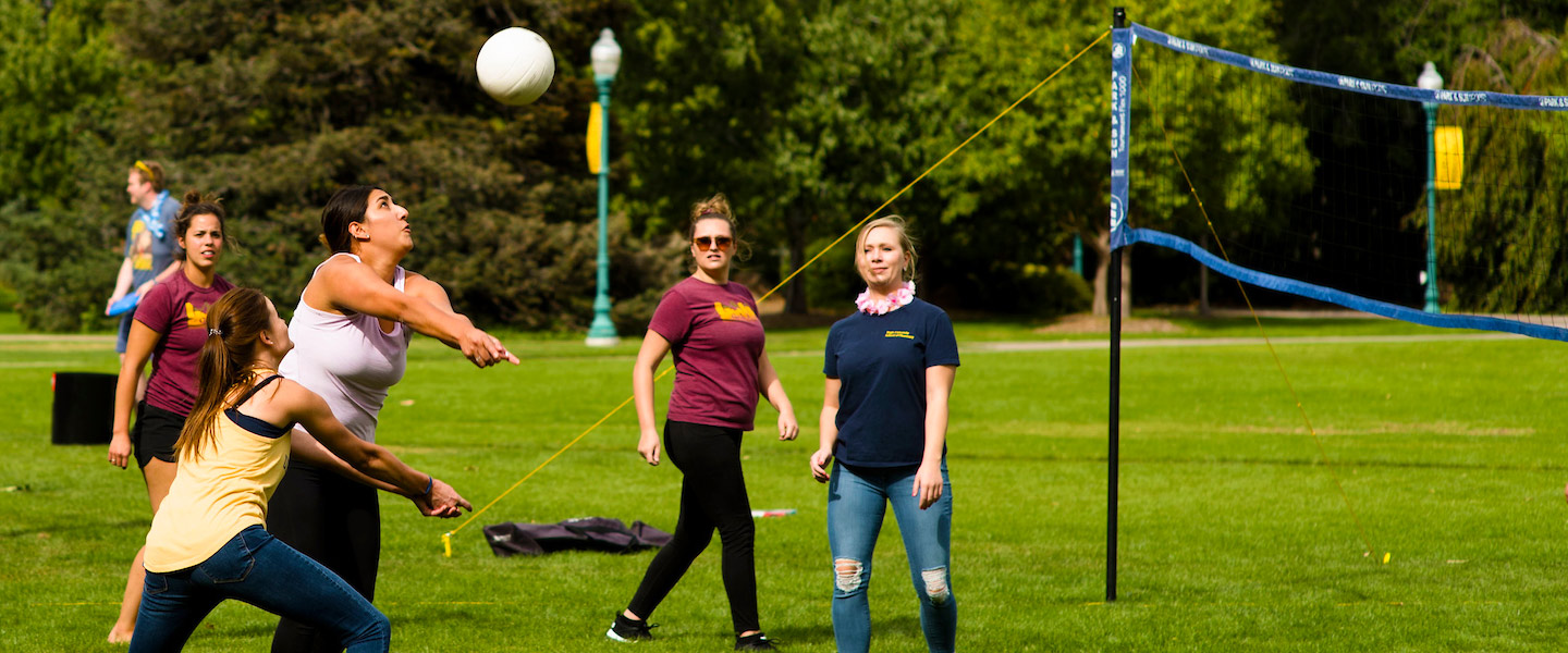 women play volleyball outdoors