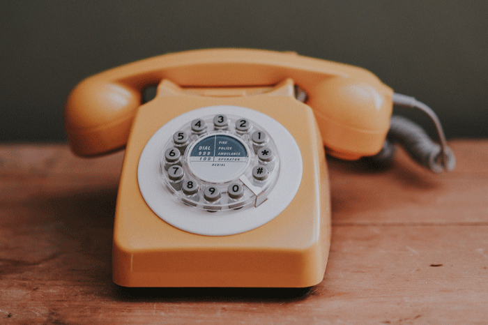 yellow rotary phone on table