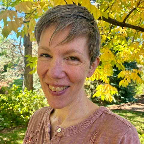 Paula Sapienza headshot. Yellow leaves make up her background on a nice outdoor trail