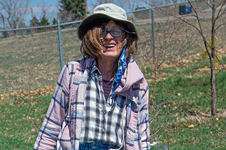 Sonia John smiles for a photo while with the trees of Regis