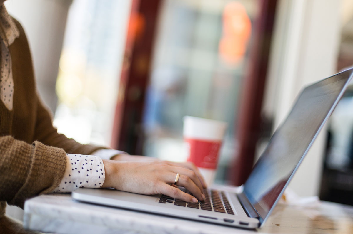 woman typing at computer in cafe