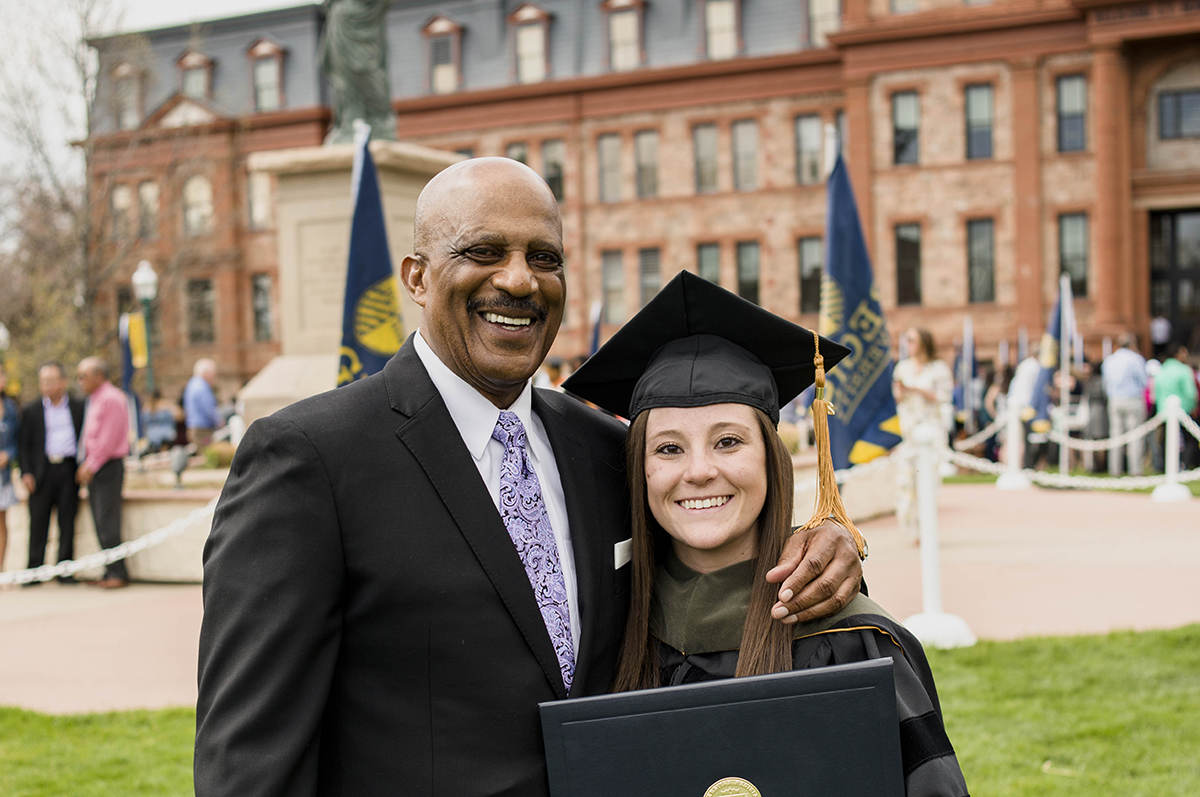 Lonnie Porter and Monique Gonzales pause for a picture after Monique received her doctorate from Regis