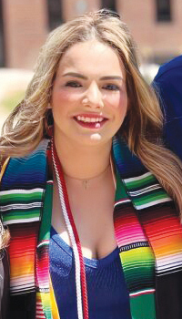 Alma Borunda-Granillo poses for a photo wearing her graduation regalia at commencement on Regis' Northwest Denver campus