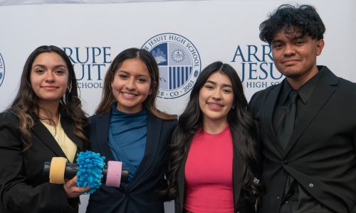 students pose for a photo on a stage