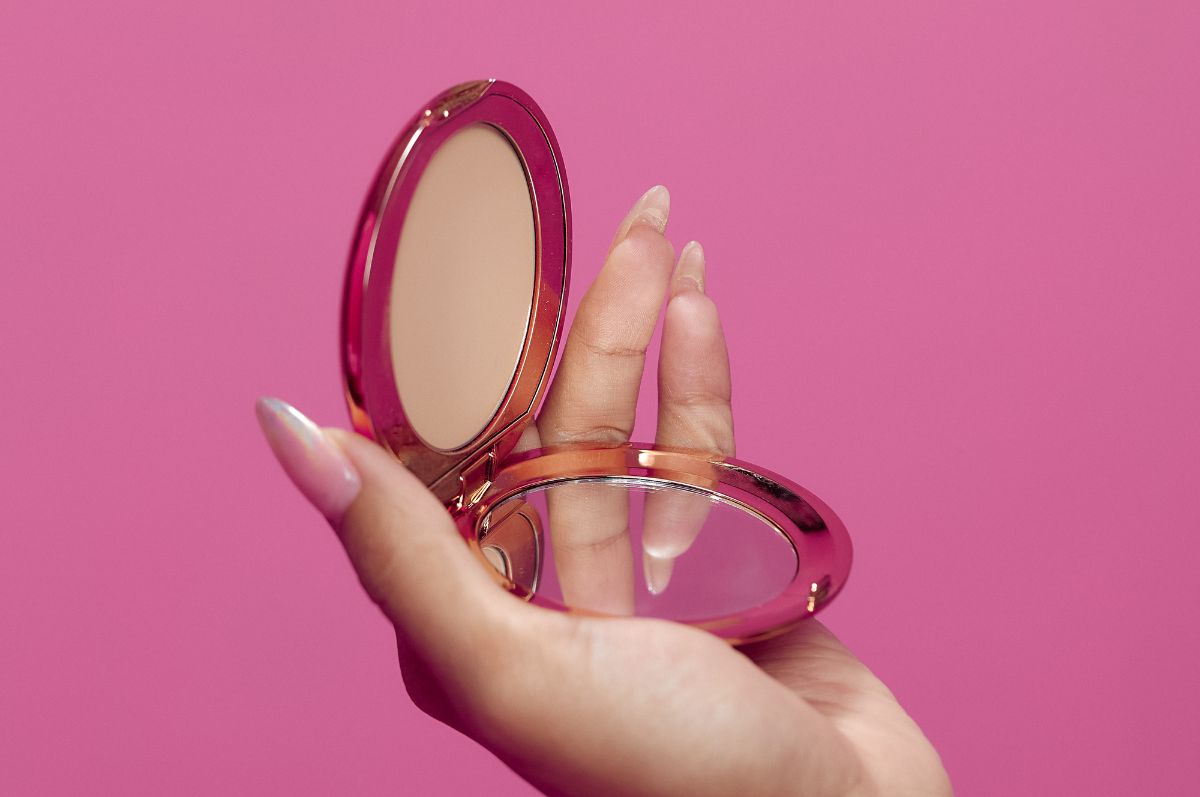 hand holds pink mirror