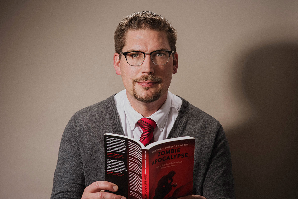 Bryan Hall with his book "An Ethical Guidebook to the Zombie Apocalypse"