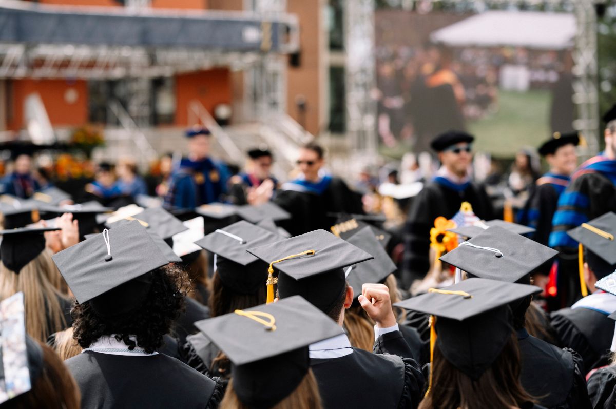 graduates sit on the quad at commencement