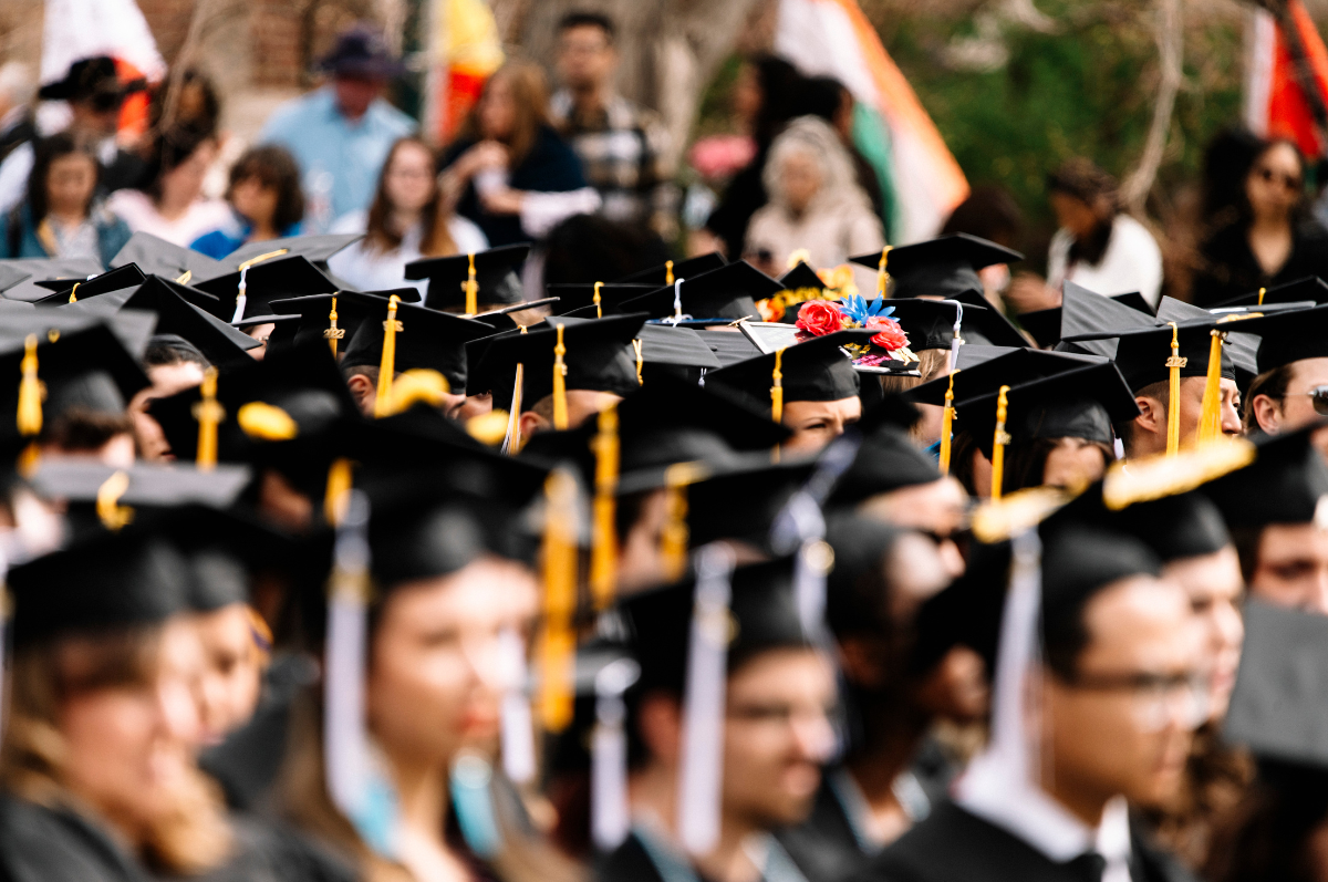 crowd of students wearing black graduation caps