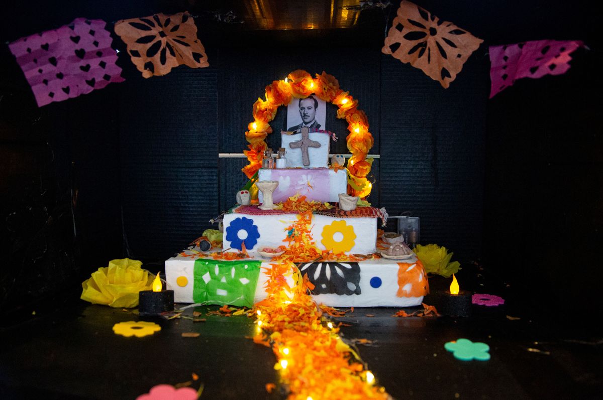 a Dia de Los Muertos ofrenda with lights and a black background