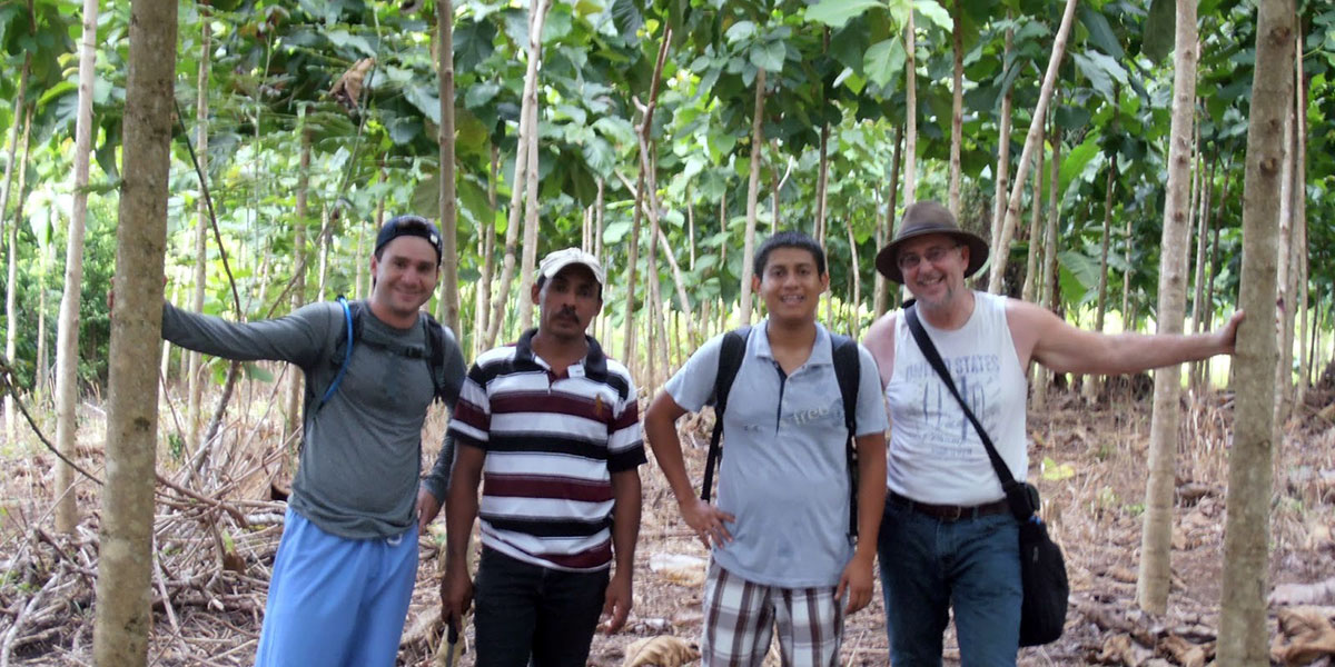 professor Don Bush and associates pose for a photo on his tree farm in Belize