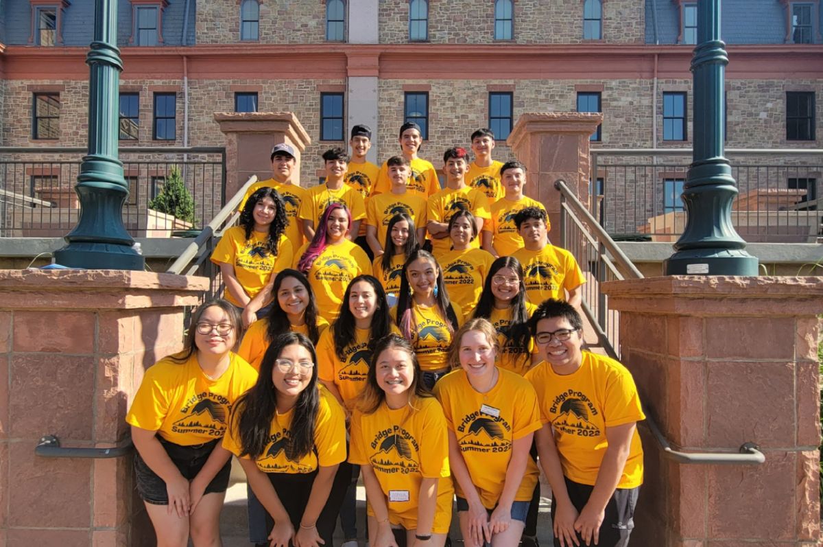 group of students smiling for photo in front of Regis Main Hall