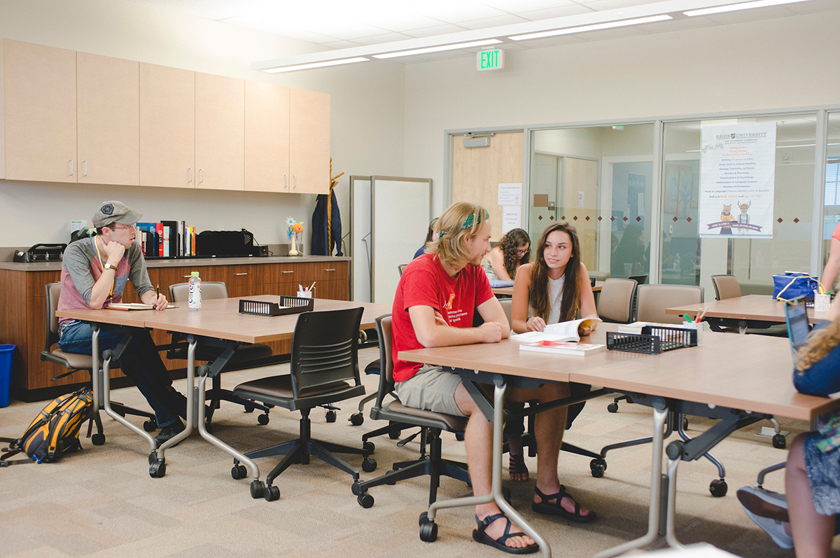 A student works with a tutor to complete an assignment in The Learning Commons at Regis University.