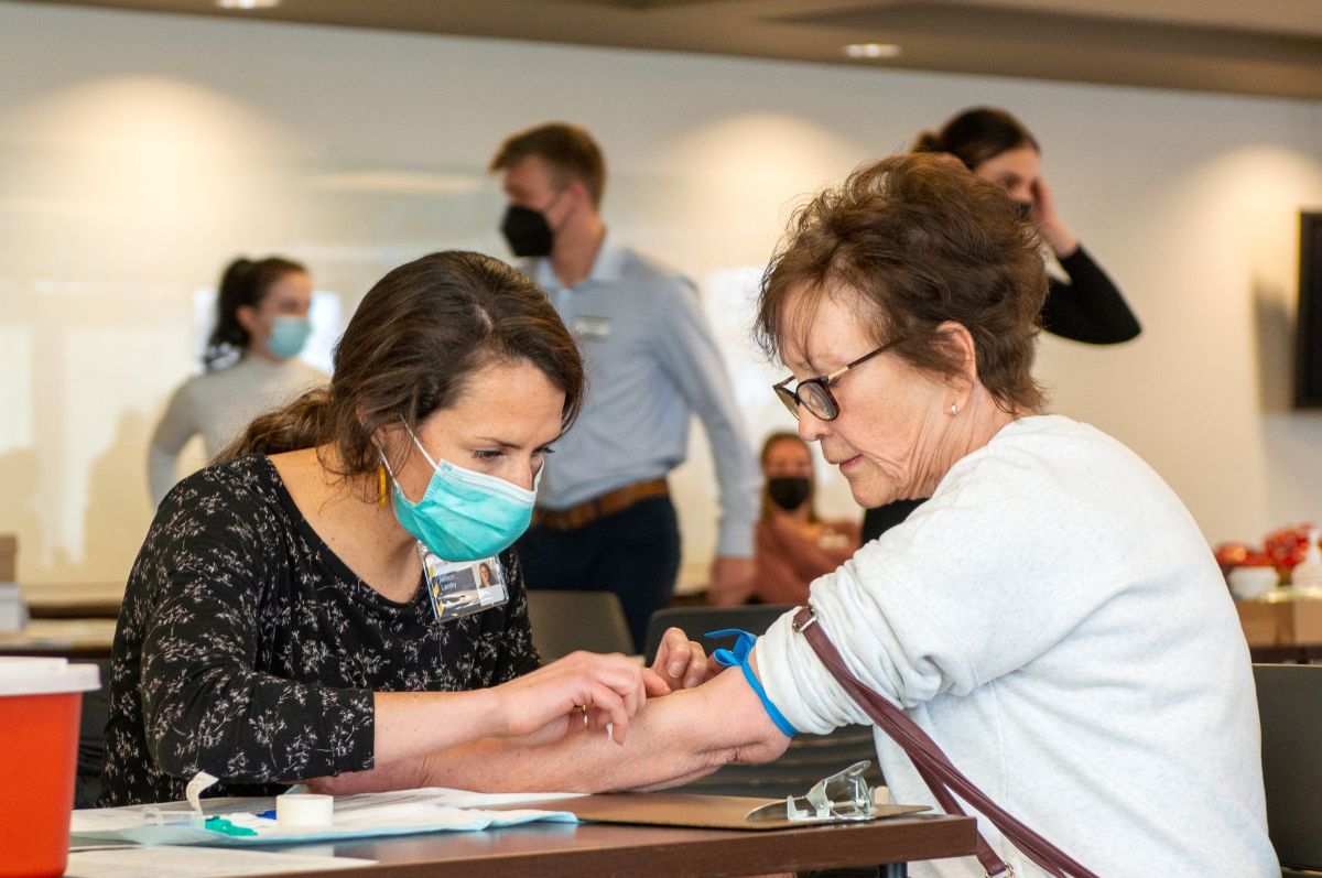 regis student prepares to draw blood