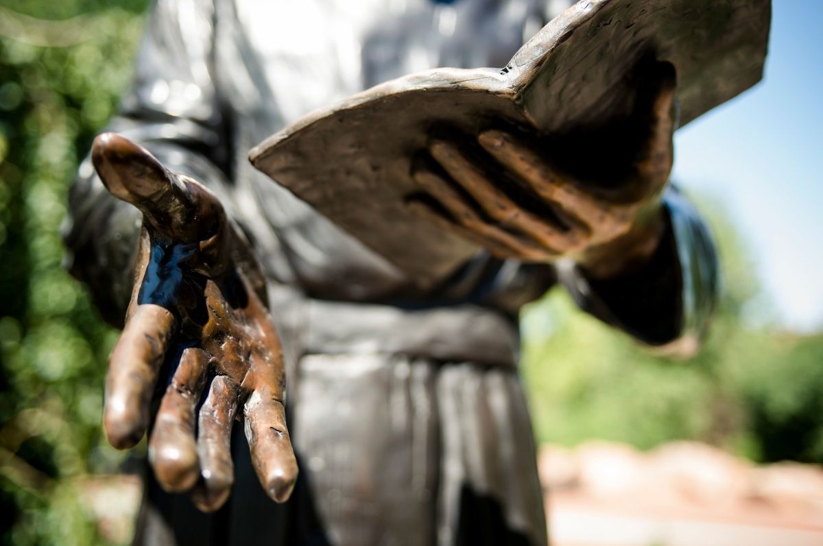 statue hands holding book