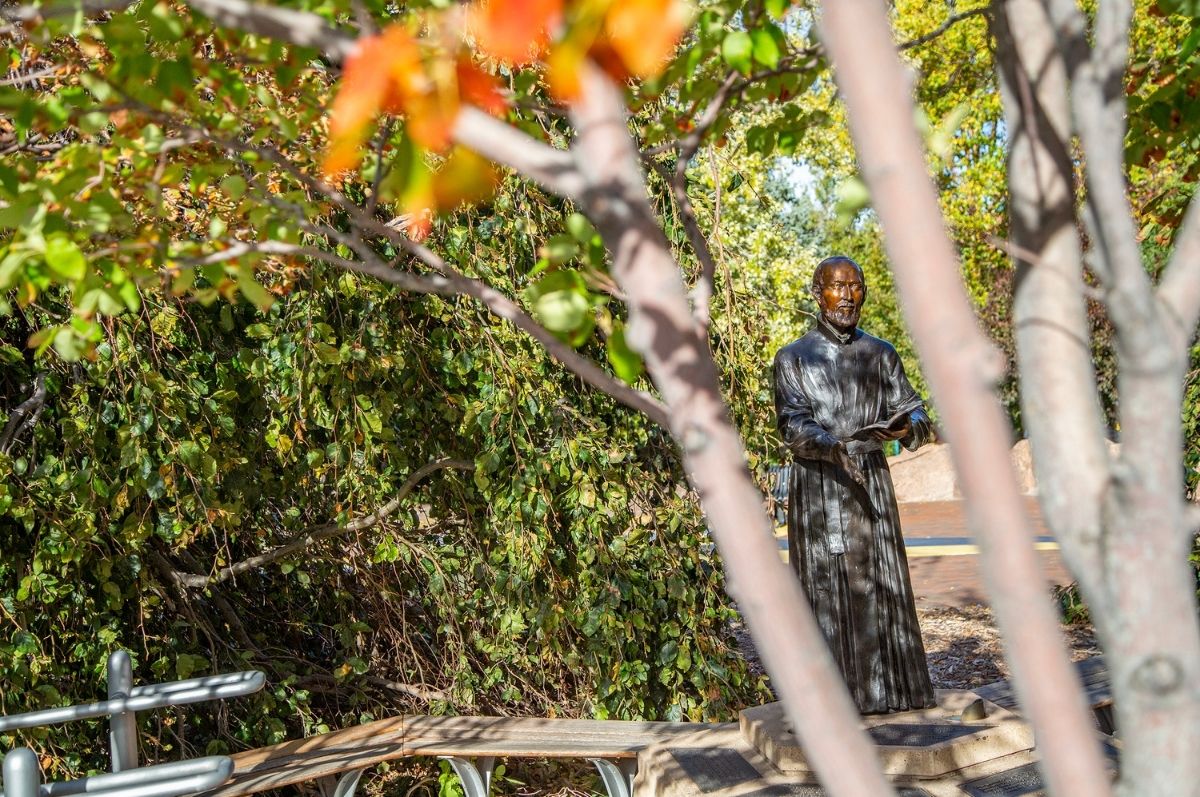 St. Ignatius statue surrounded by fall leaves