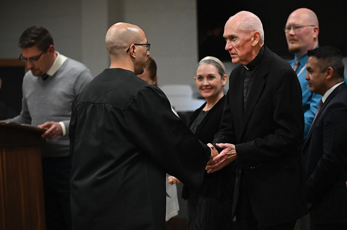 Image of two men shaking hands at graduation.