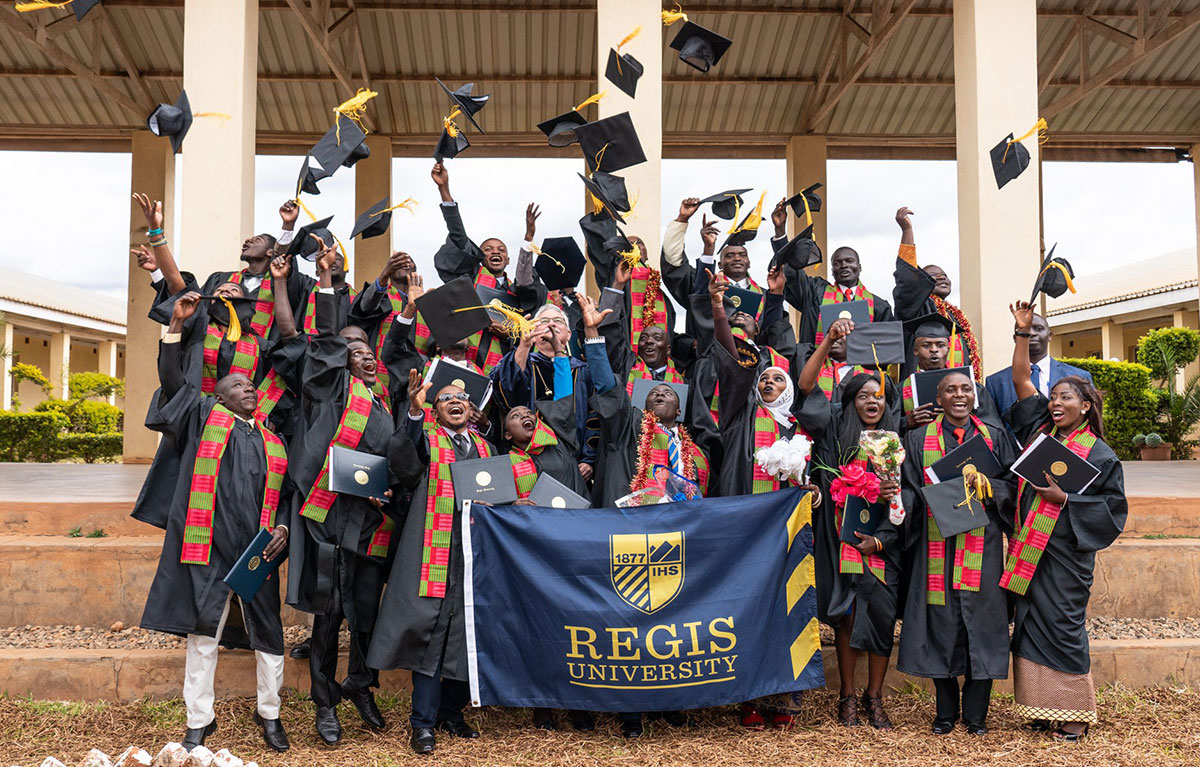 Graduates of Jesuit Worldwide Learning's diploma program throw their caps in the air