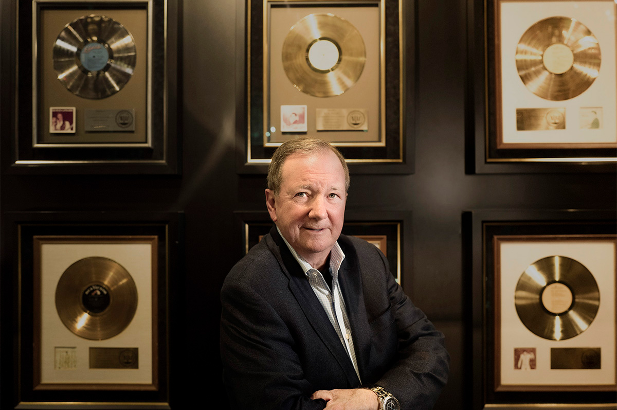 Jack Soden stands in front of Elvis Presley's gold records at Graceland