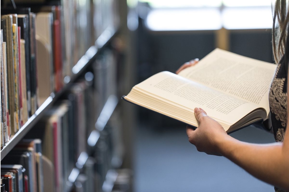 Student browsing library books in the Regis Library