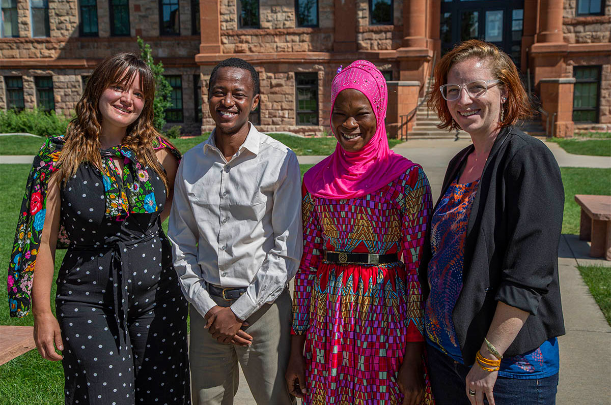 Regis University Masters of Development Practice students stand in front of Main Hall on the Northwest Denver Campus