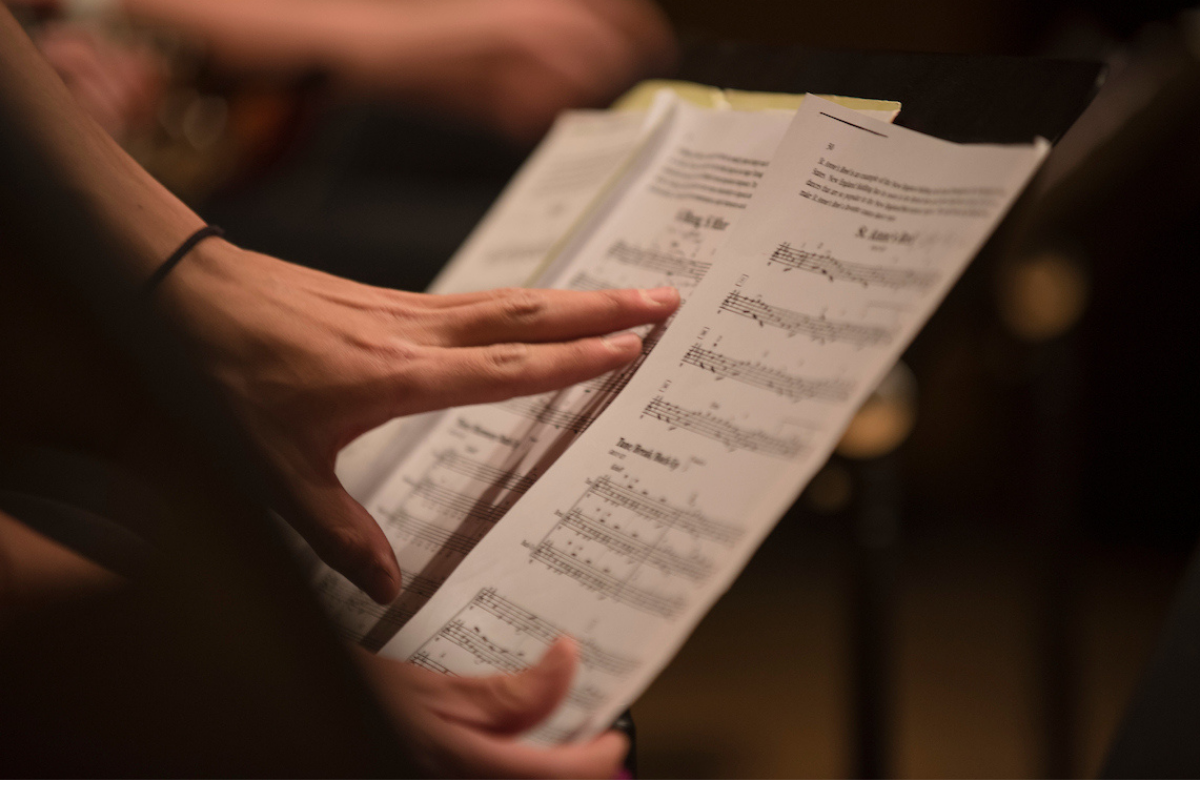 A member of Regis University's music program adjusts sheet music