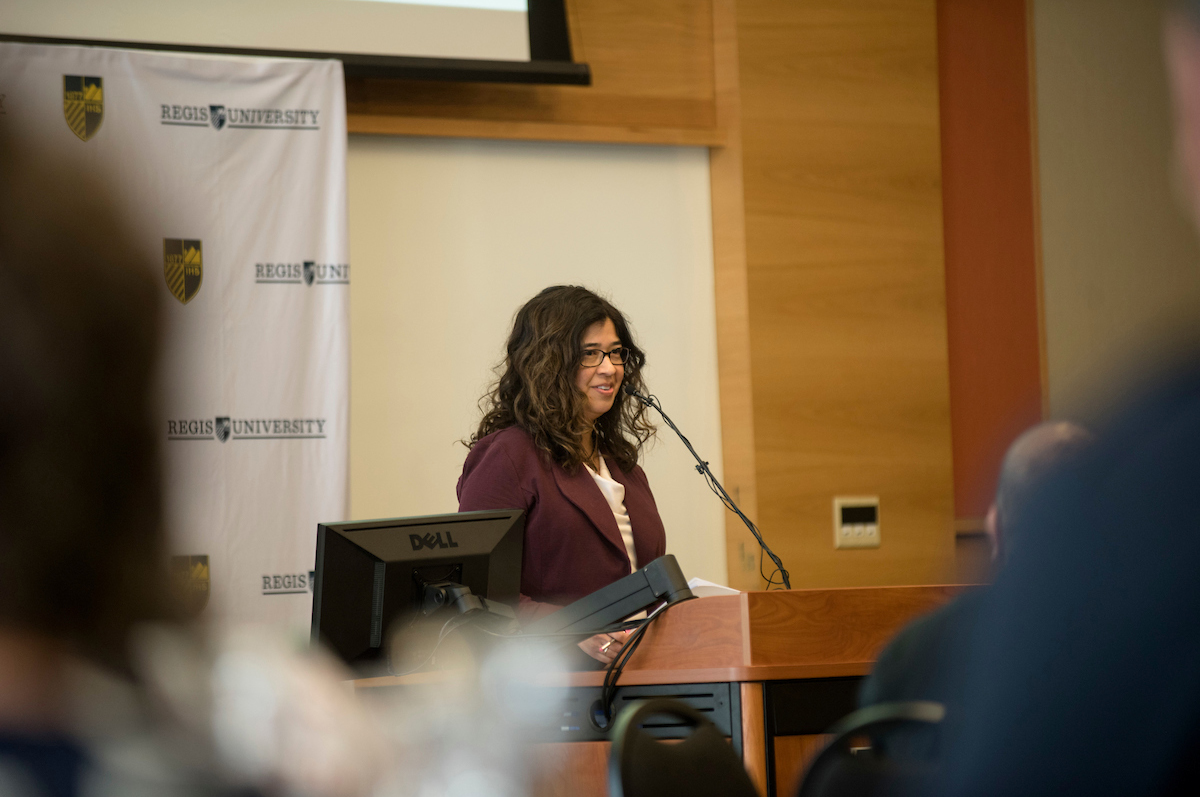 Nicki Gonzales stands at a podium giving a presentation