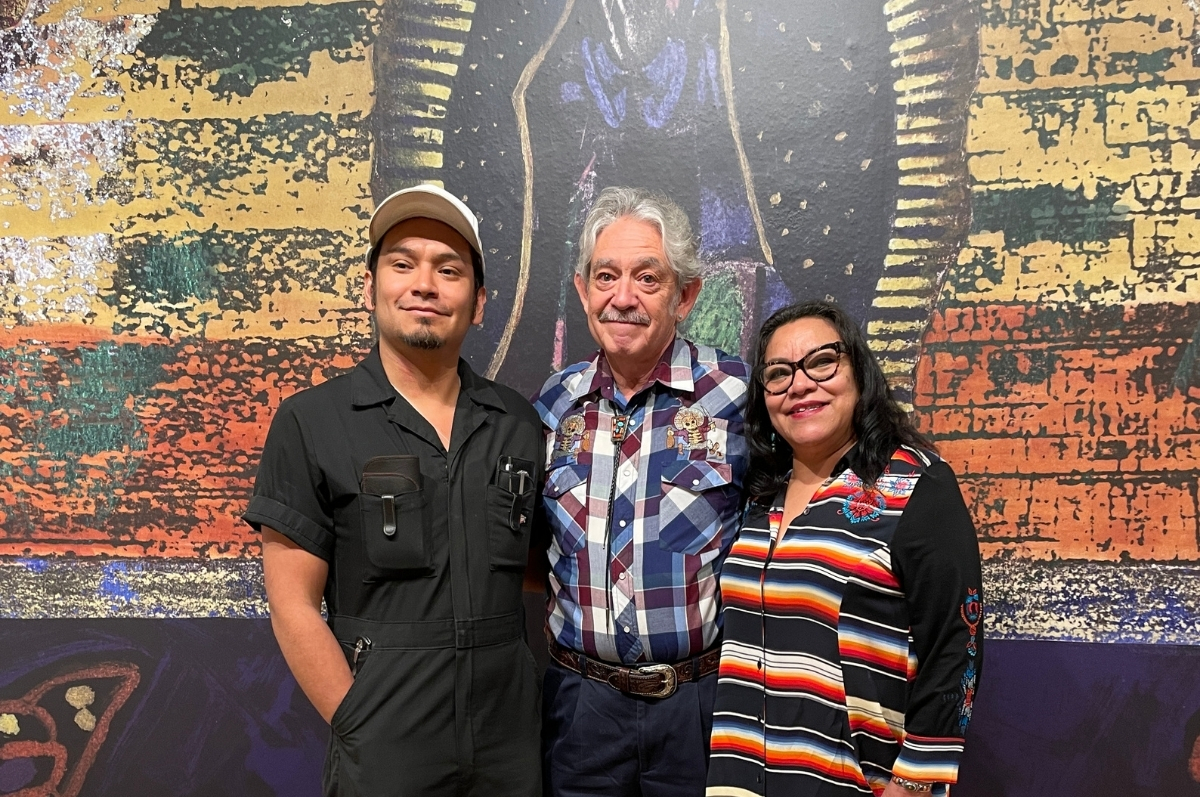 The Ortega family standing in front of an art piece at the exhibition