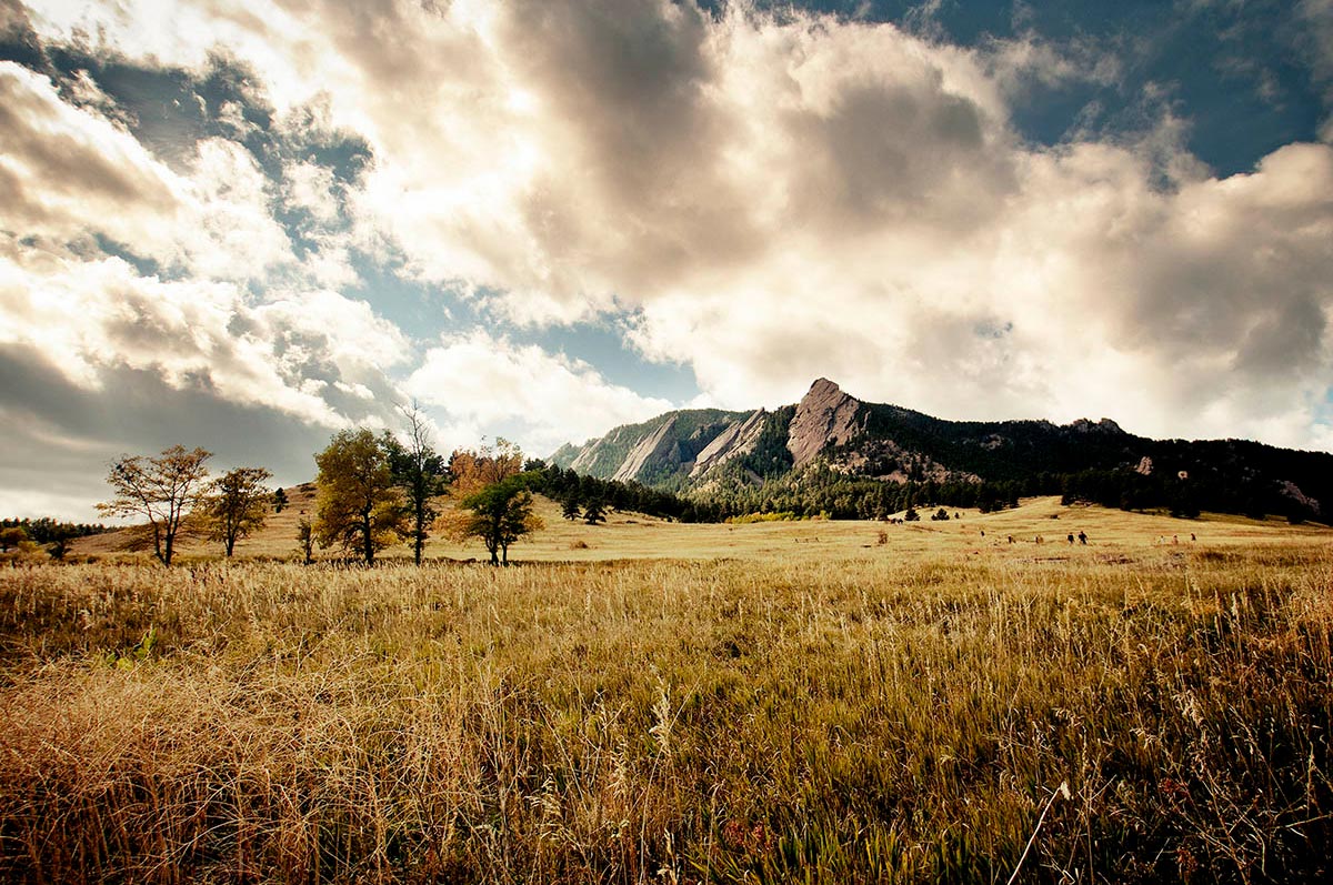 Clouds sit behind the Boulder Flatirons on sunny day