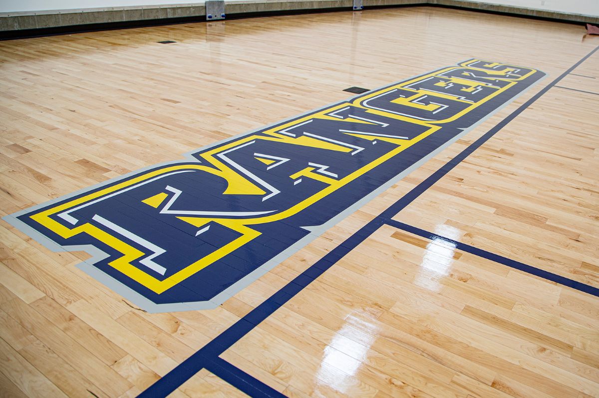 Regis Athletics printed on gym floor