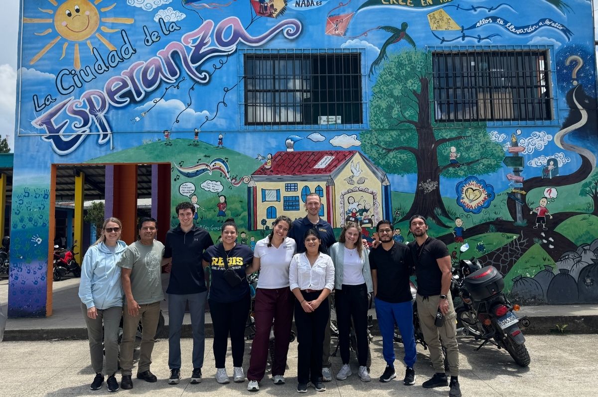 Regis DPT students posed in front of La Ciudad de la Esperanza