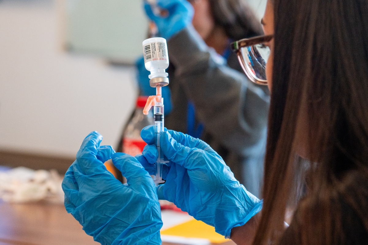 Regis Summer Health Experience program student using a syringe