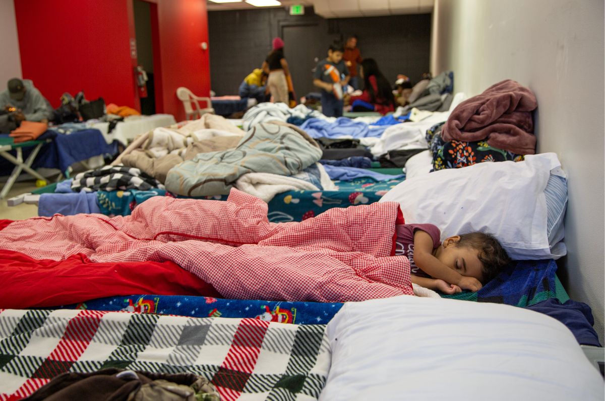 a child sleeps on a cot in the Regis Welcome Center