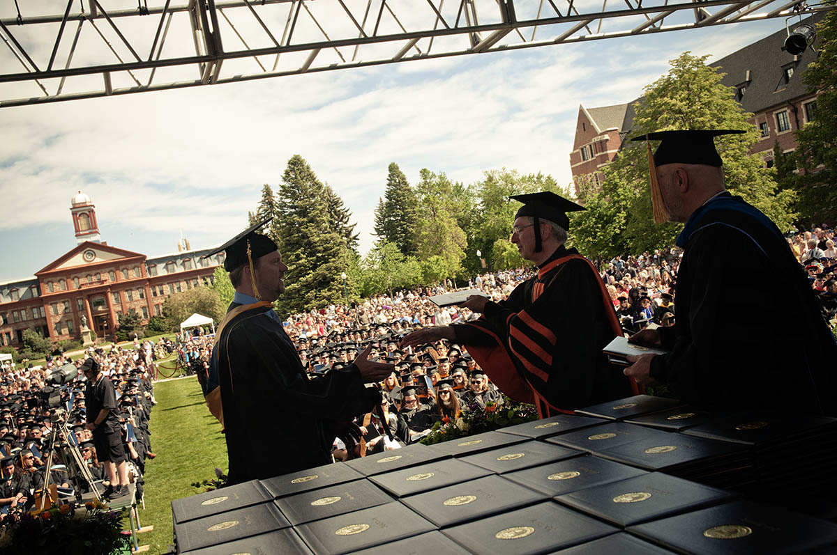 student being handed degree at commencement