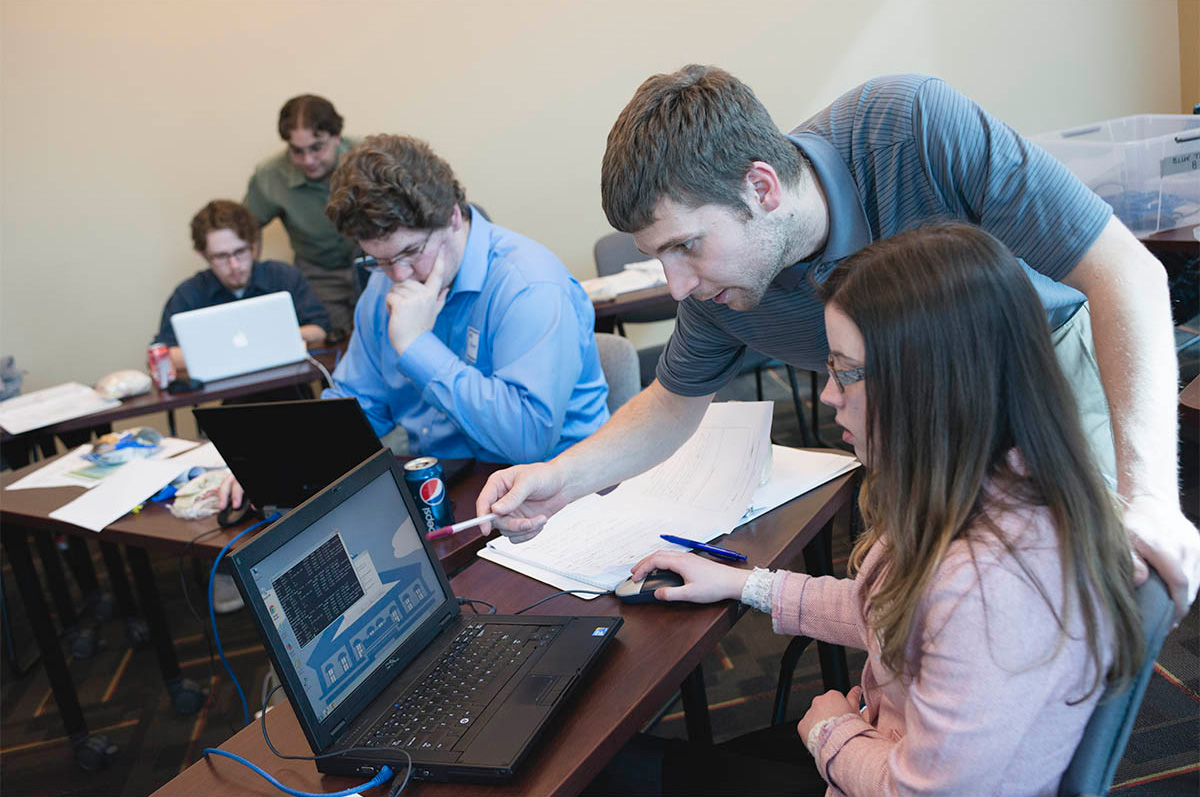 two students look at a computer screen during a cybersecurity competition