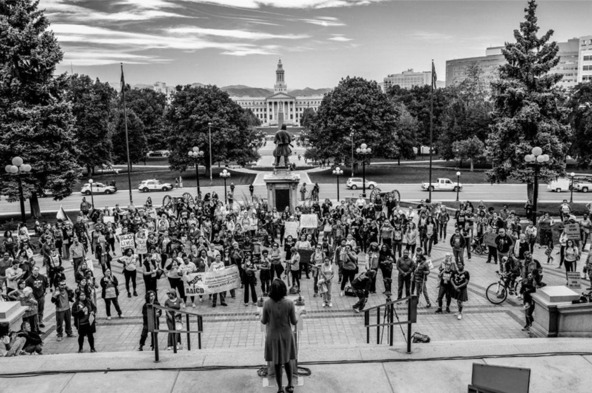 a crowd gathers at the Colorado State Capitol