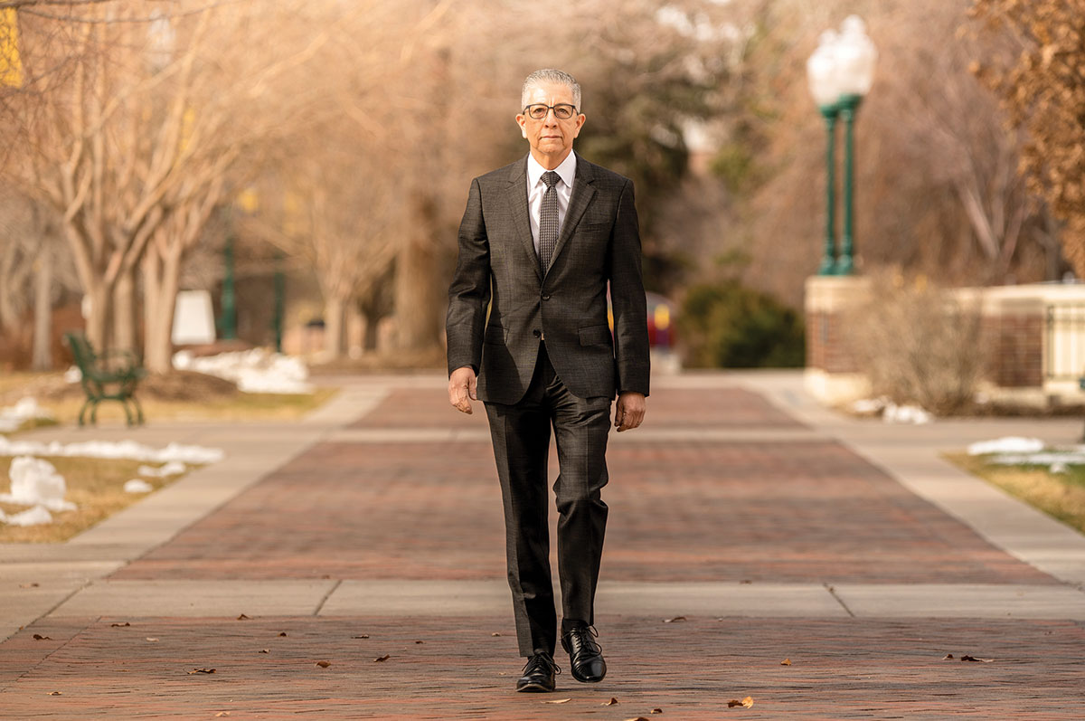 Salvador Aceves walks outdoors on the Regis University Northwest Denver campus.