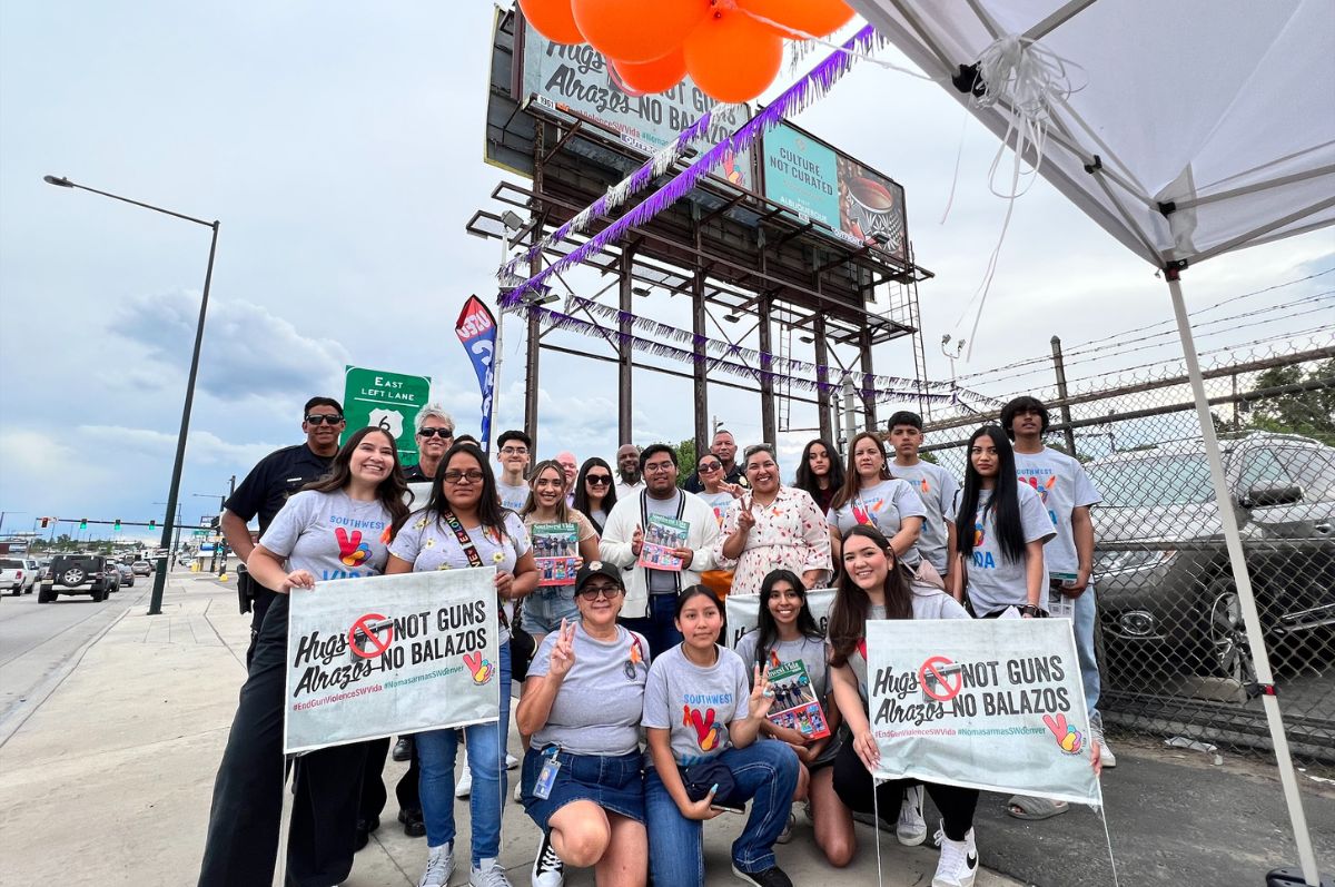 students stand in front of a billboard with signs